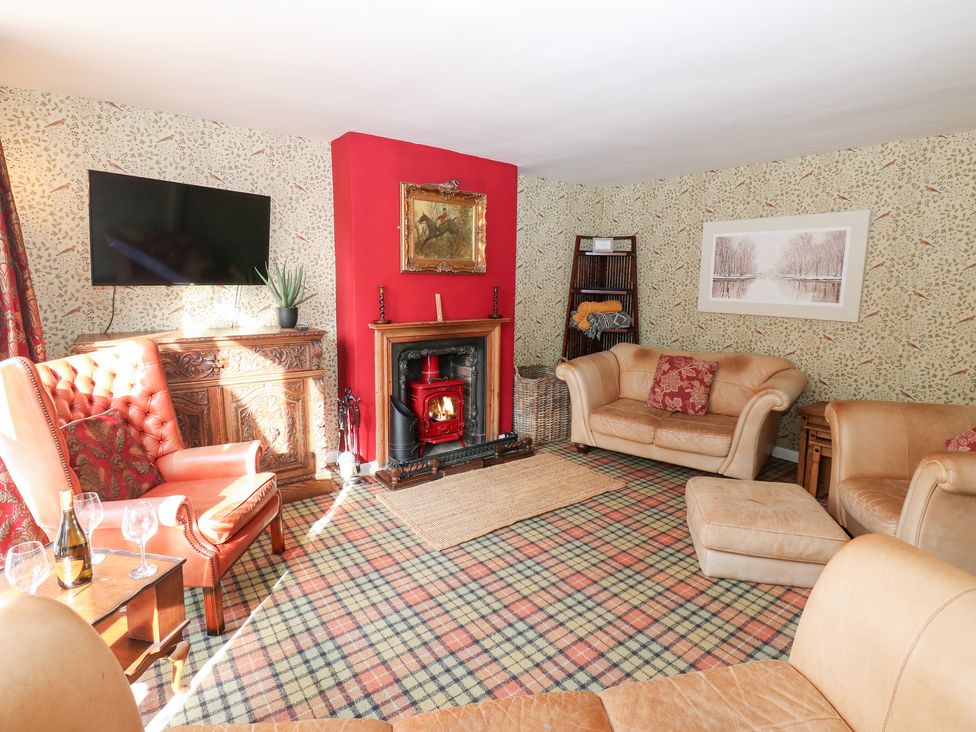 A living room with a fireplace and television at 2 The Coach House in Romaldkirk near Middleton-in-Teesdale