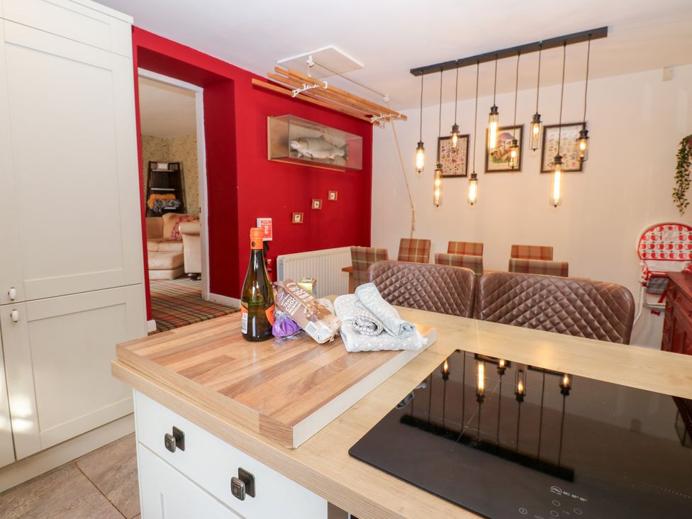 A kitchen with an island and bar stools at 2 The Coach House Romaldkirk near Middleton-in-Teesdale