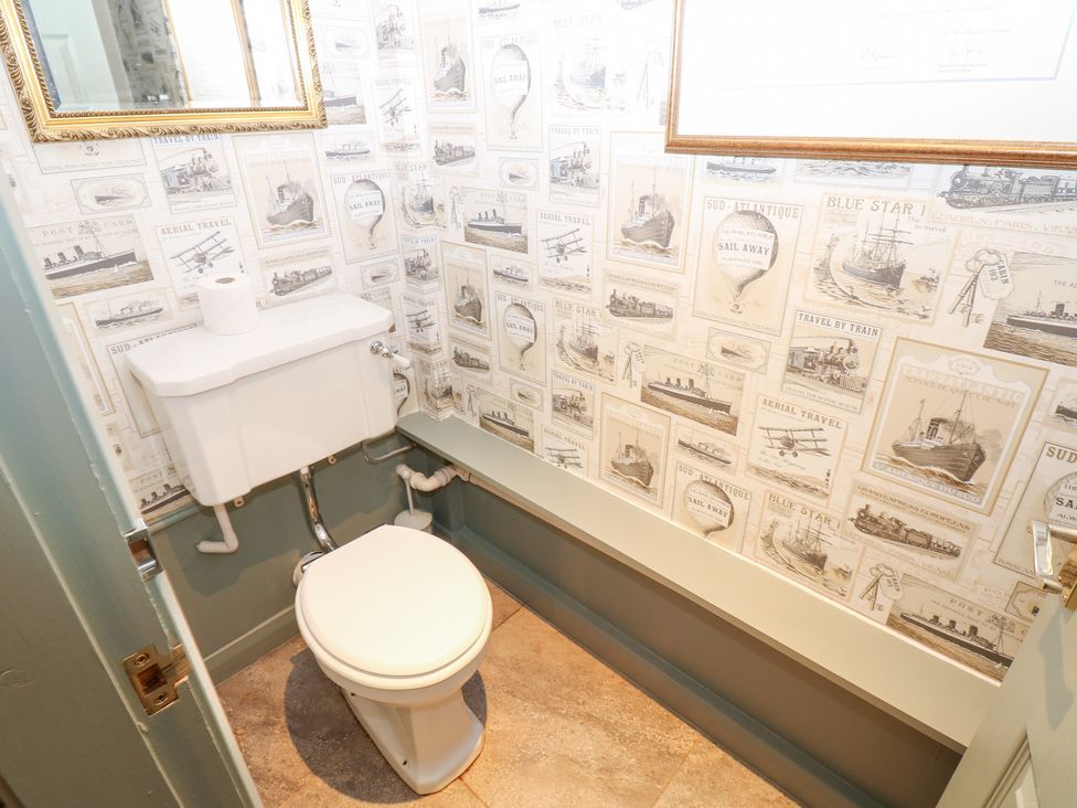 A bathroom with a toilet and decorative wallpaper at 2 The Coach House Romaldkirk near Middleton-in-Teesdale
