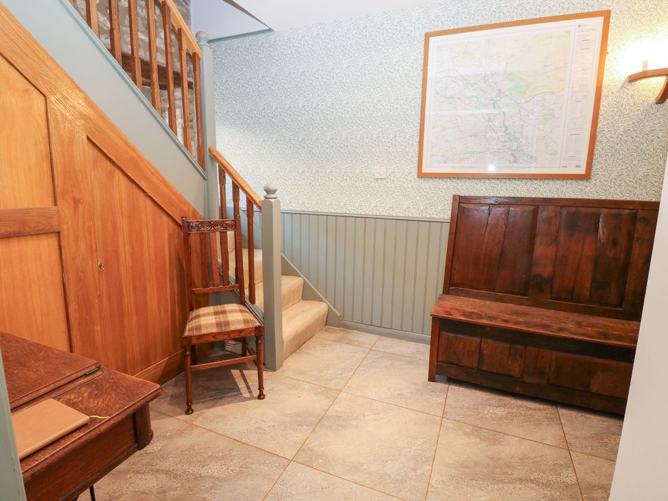 An entrance hall with a staircase and seating at 2 The Coach House in Romaldkirk near Middleton-in-Teesdale
