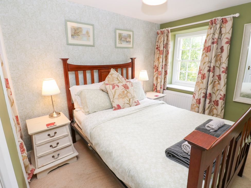 A bedroom with a bed and bedside table at 2 The Coach House Romaldkirk near Middleton-in-Teesdale