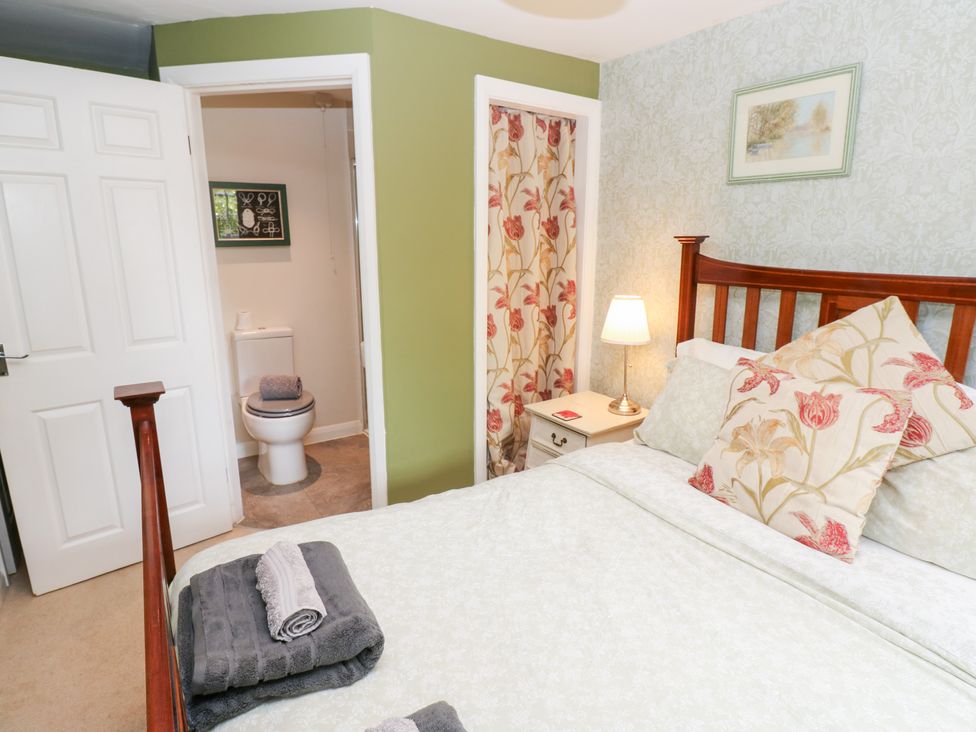 A bedroom with a bed and visible bathroom entrance at 2 The Coach House Romaldkirk near Middleton-in-Teesdale
