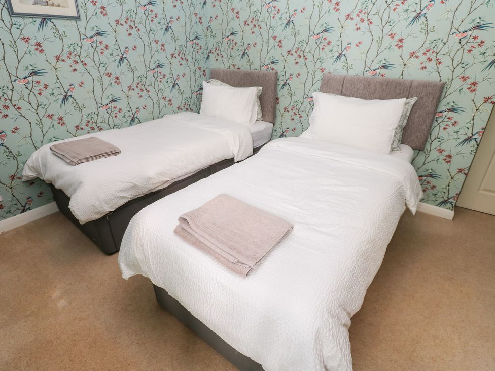 A bedroom with two single beds and towels at 2 The Coach House in Romaldkirk near Middleton-in-Teesdale