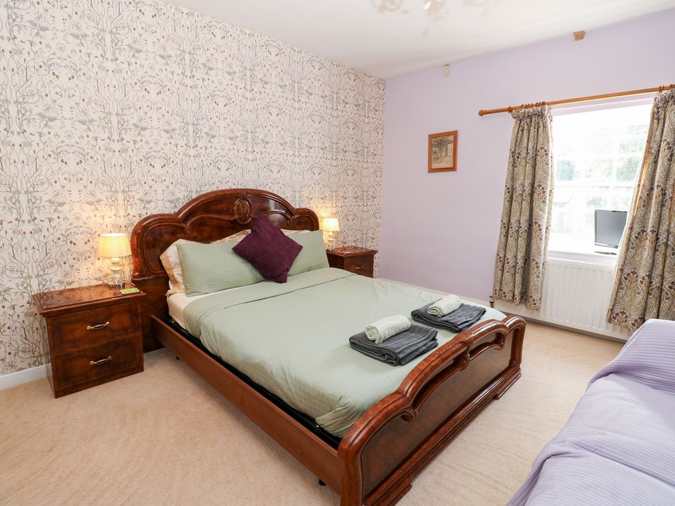 A bedroom with a bed and nightstand at 2 The Coach House Romaldkirk near Middleton-in-Teesdale