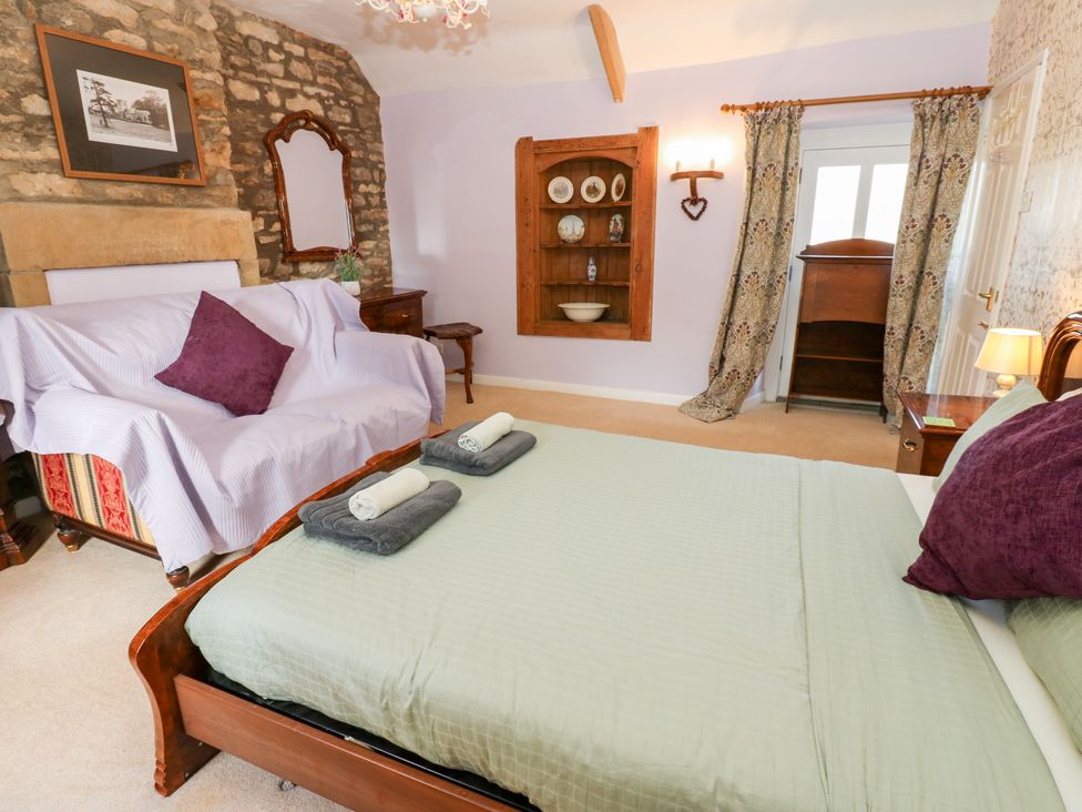 A bedroom with a bed and a sofa at 2 The Coach House, Romaldkirk near Middleton-in-Teesdale