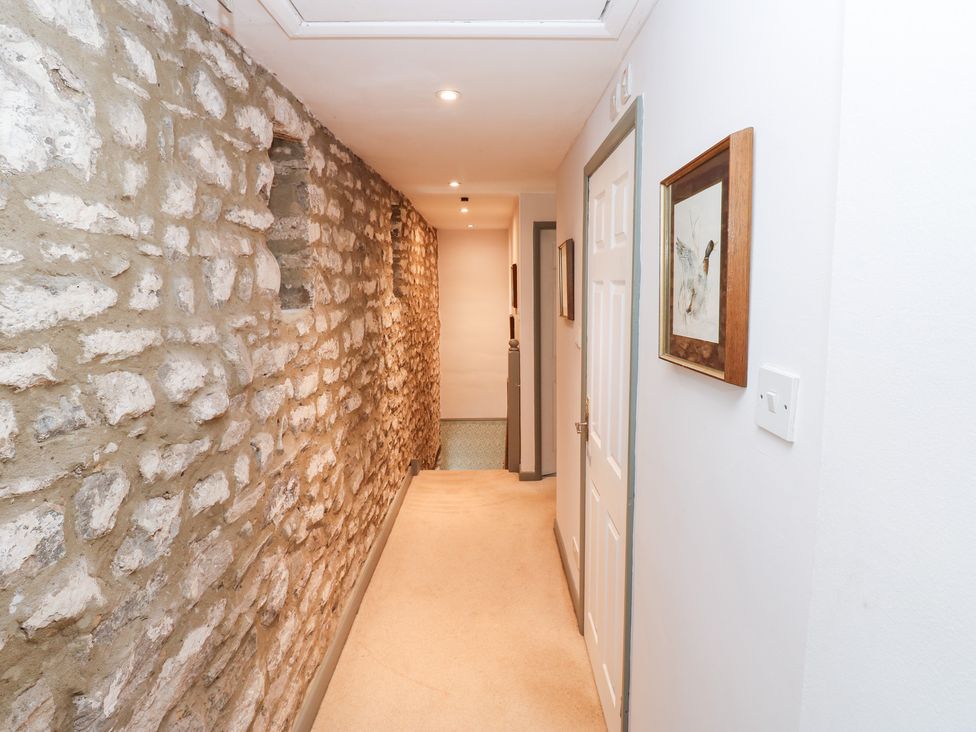A hallway with a stone wall and framed picture at 2 The Coach House Romaldkirk near Middleton-in-Teesdale