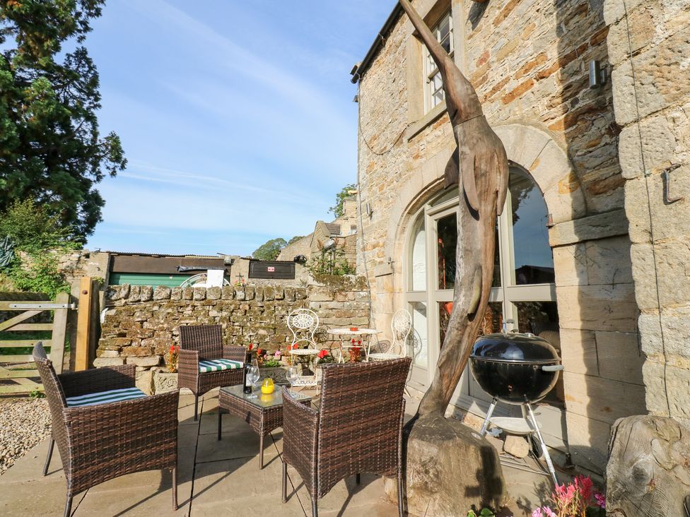 An outdoor area with a table and chairs at 2 The Coach House Romaldkirk near Middleton-in-Teesdale