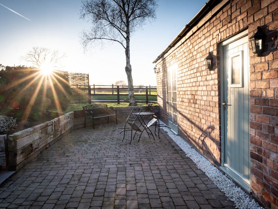 An outdoor area with a table and chairs at Barnfields Holiday Cottage Kingsley