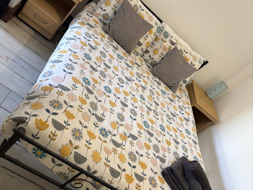 A bedroom with a bed and nightstand at Herby's Retreat Sutton-On-Sea