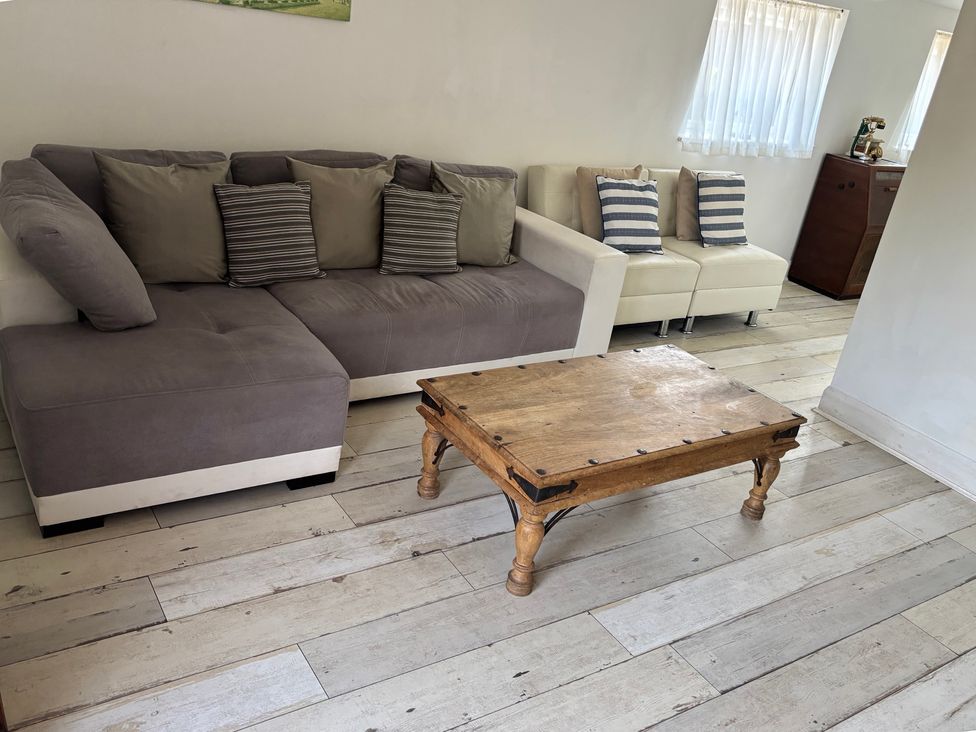 A living room with a sofa and coffee table at Herby's Retreat in Sutton-On-Sea