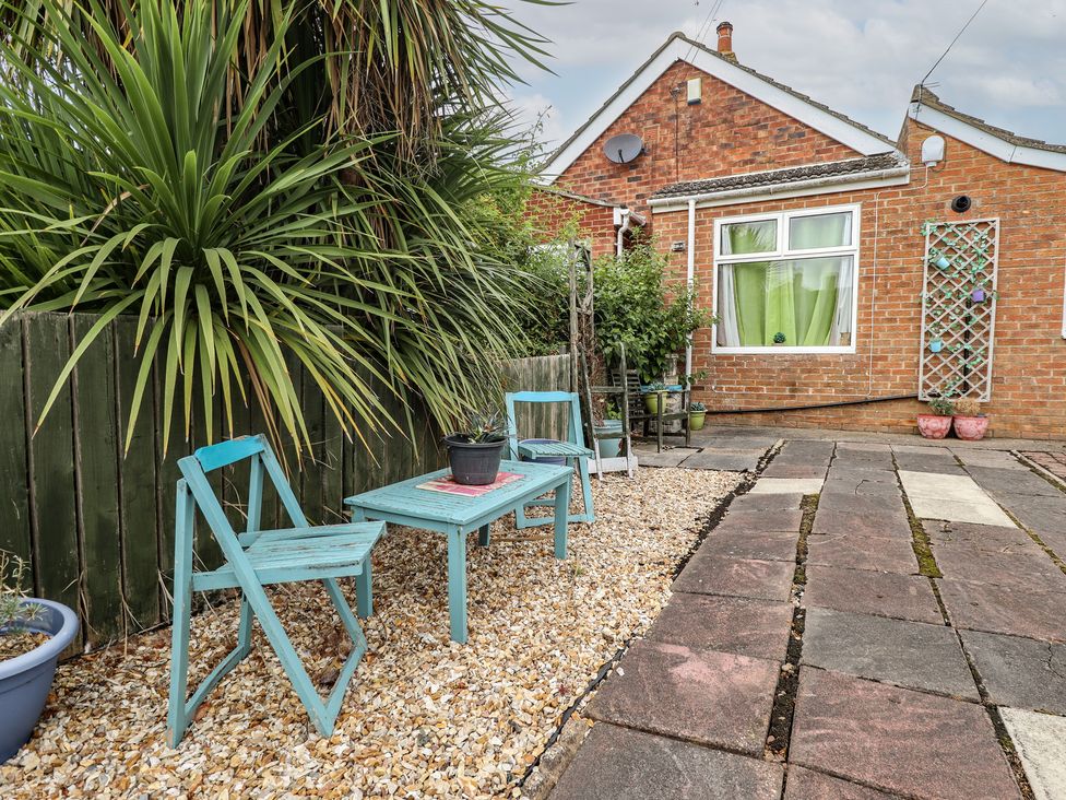 A garden with chairs and a table at Herby's Retreat Sutton-On-Sea