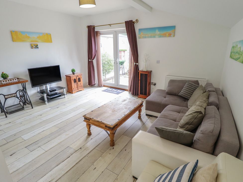 A living room with a sofa, coffee table, and television at Herby's Retreat, Sutton-On-Sea
