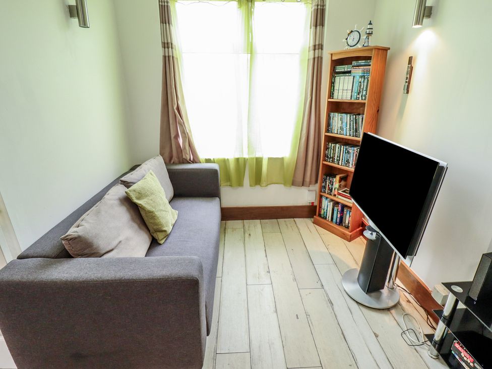 A living room with a sofa and television at Herby's Retreat in Sutton-On-Sea
