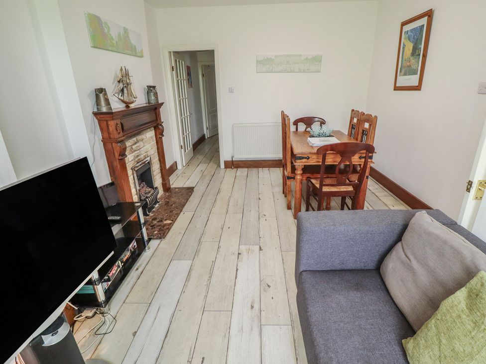 A living room with a sofa and dining area at Herby's Retreat in Sutton-On-Sea