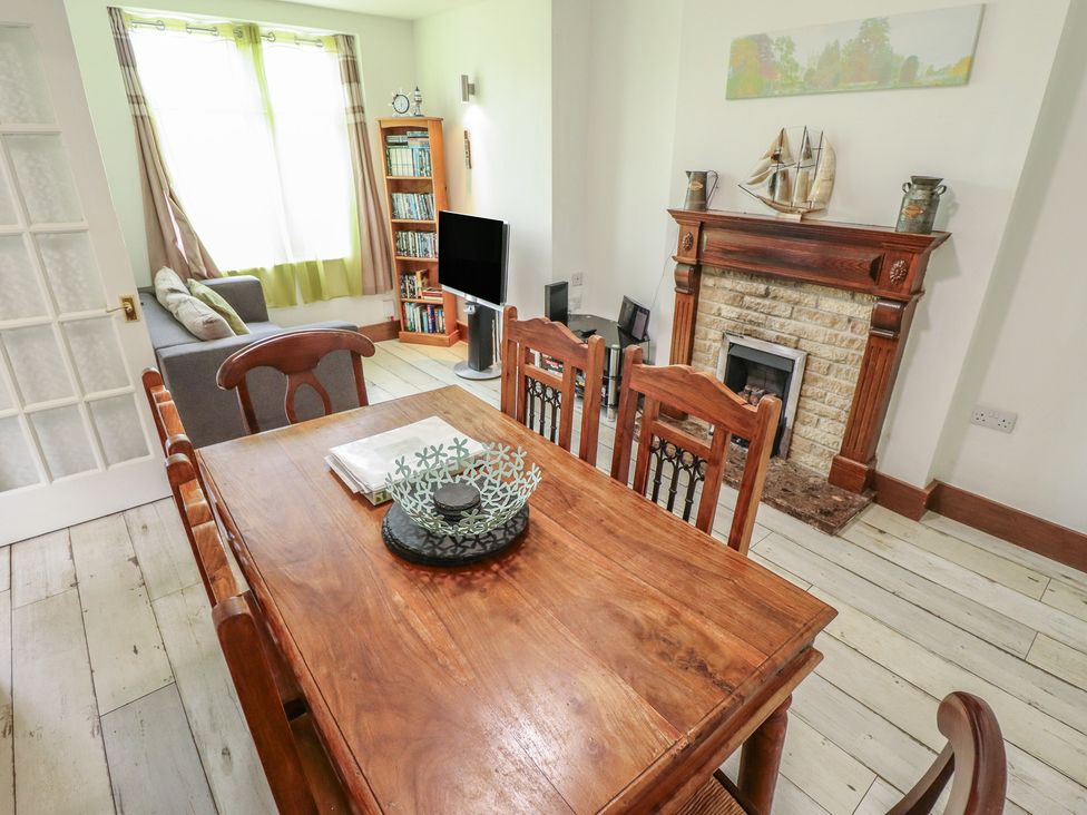 A living room with a dining table and chairs at Herby's Retreat in Sutton-On-Sea