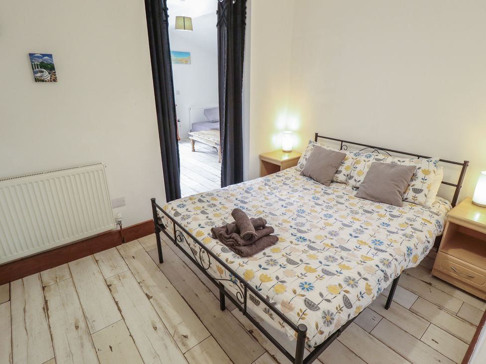 A bedroom with a bed and lamps at Herby's Retreat in Sutton-On-Sea