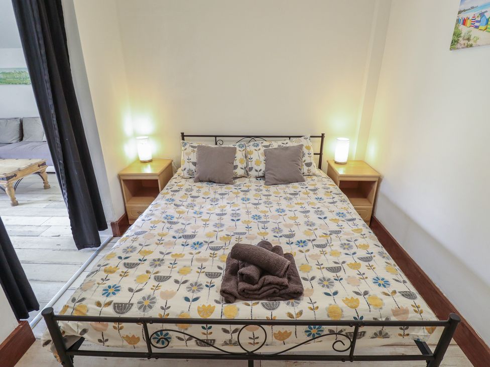 A bedroom with a bed and bedside tables at Herby's Retreat in Sutton-On-Sea