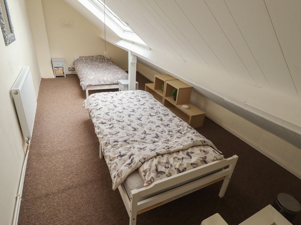 A bedroom with two beds and a shelf at Herby's Retreat Sutton-On-Sea