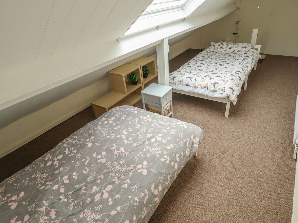 A bedroom with two beds and a shelf at Herby's Retreat Sutton-On-Sea