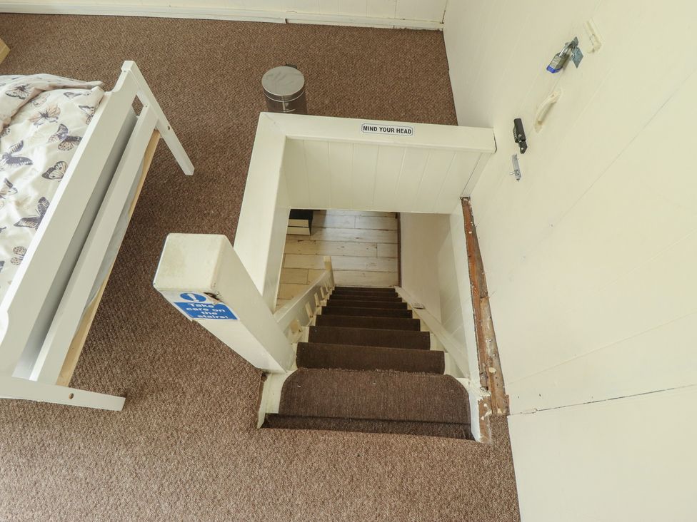 A staircase leading down from a bedroom at Herby's Retreat Sutton-On-Sea
