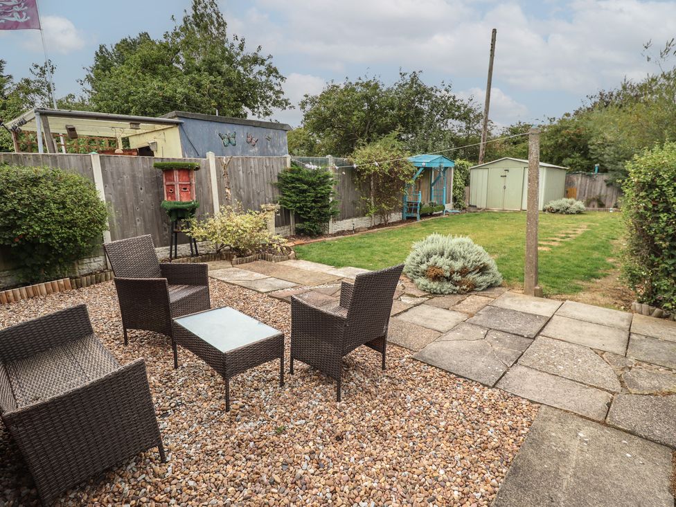 A garden with seating area and shed at Herby's Retreat in Sutton-On-Sea