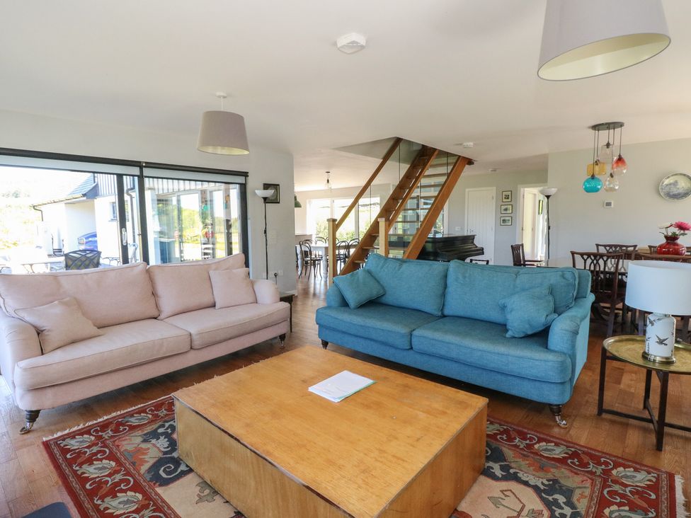 A living room with two sofas and a wooden coffee table near a staircase at Sobrachan in Kilmartin