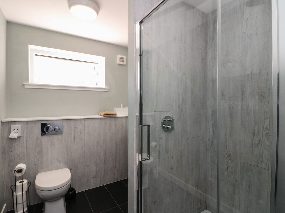 A bathroom with a toilet and a glass shower enclosure at Sobrachan in Kilmartin