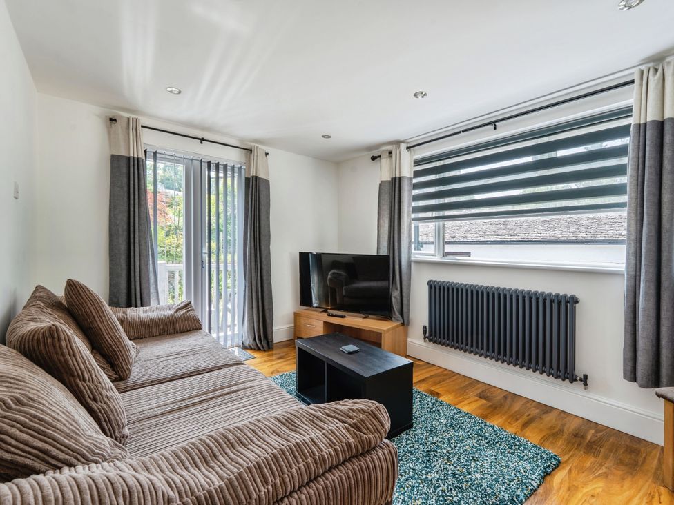 A living room with a sofa and television at Mylnebeck Lodge in Bowness-on-Windermere