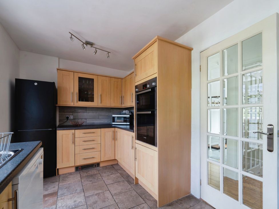 A kitchen with appliances and cabinetry at Mylnebeck Lodge Bowness-on-Windermere