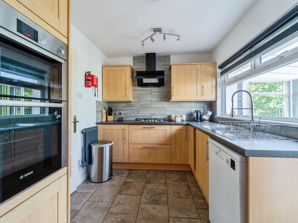 A kitchen with cabinets and appliances at Mylnebeck Lodge in Bowness-on-Windermere