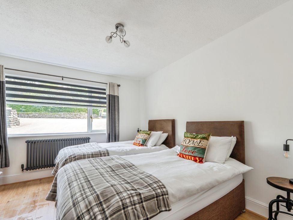 A bedroom with two beds and a window at Mylnebeck Lodge in Bowness-on-Windermere
