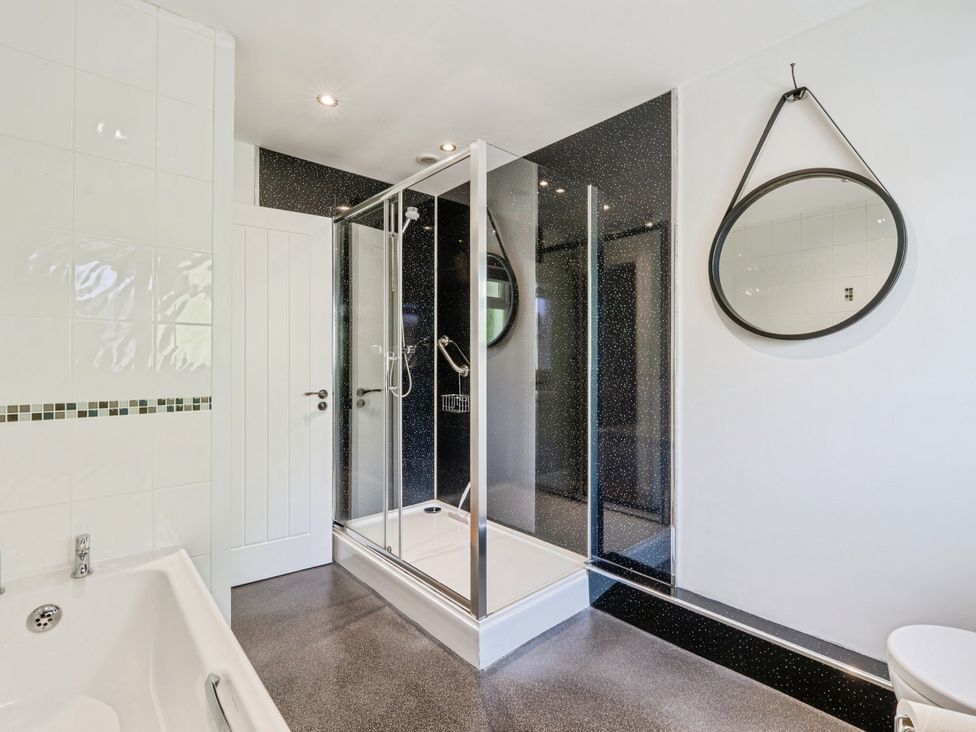 A bathroom with a shower and bathtub at Mylnebeck Lodge in Bowness-on-Windermere