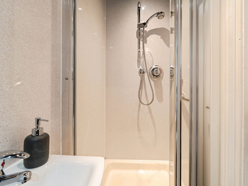 A shower area with a sink and soap dispenser at Mylnebeck Lodge in Bowness-on-Windermere
