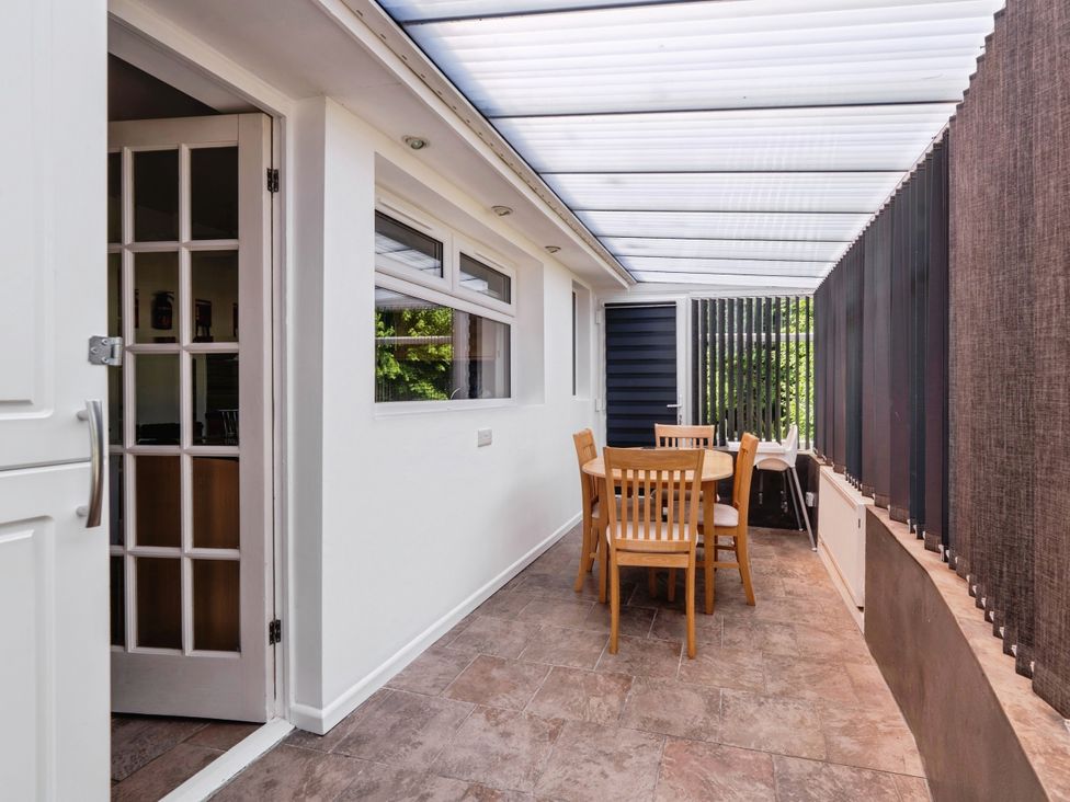 A conservatory with a table and chairs at Mylnebeck Lodge in Bowness-on-Windermere