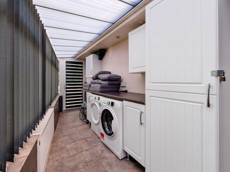 A laundry room with a washing machine and tumble dryer at Mylnebeck Lodge in Bowness-on-Windermere
