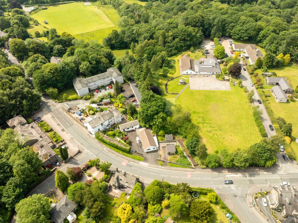 An aerial view of a residential area with buildings and greenery at Mylnebeck Lodge in Bowness-on-Windermere