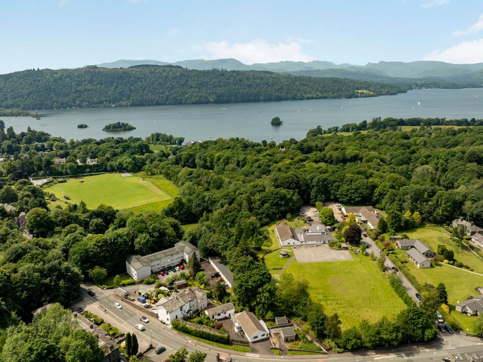 An aerial view of a lake surrounded by trees and buildings at Mylnebeck Lodge Bowness-on-Windermere