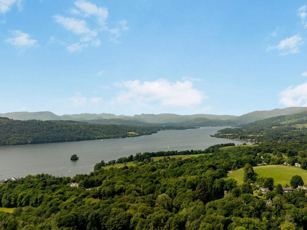 A view of a lake surrounded by greenery and mountains at Mylnebeck Lodge in Bowness-on-Windermere