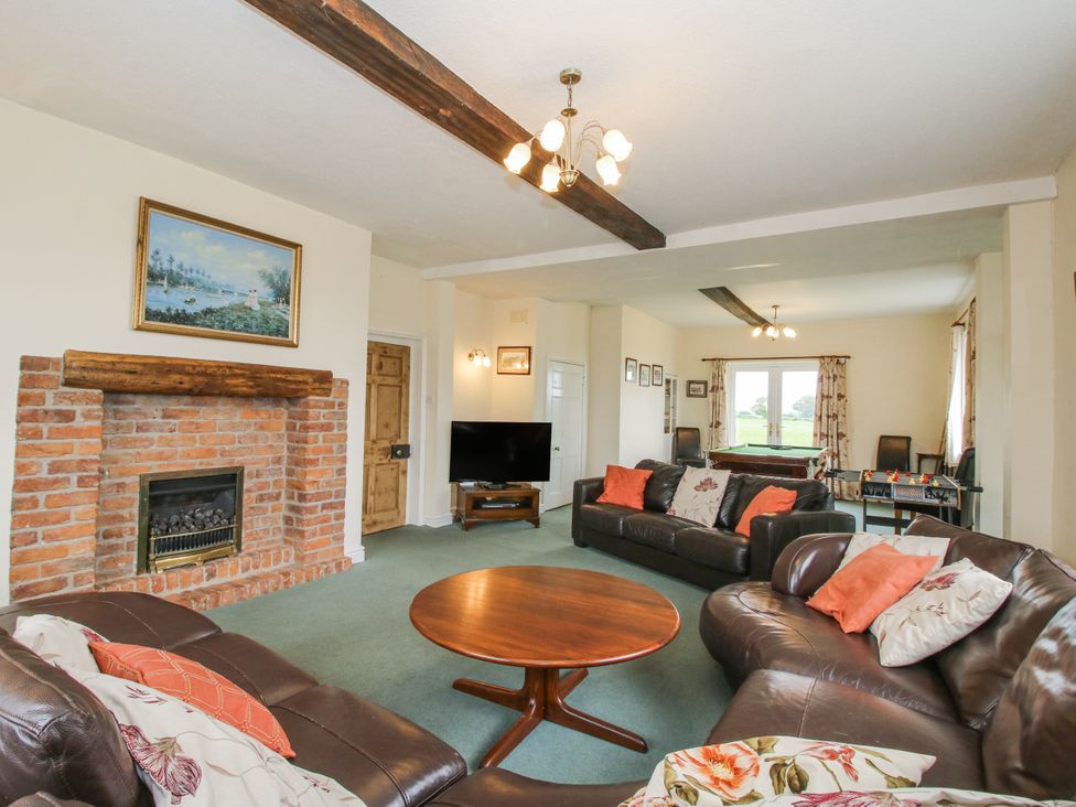A living room with a fireplace and television at The Manor House at Kenwick Lodge Cockshutt near Ellesmere