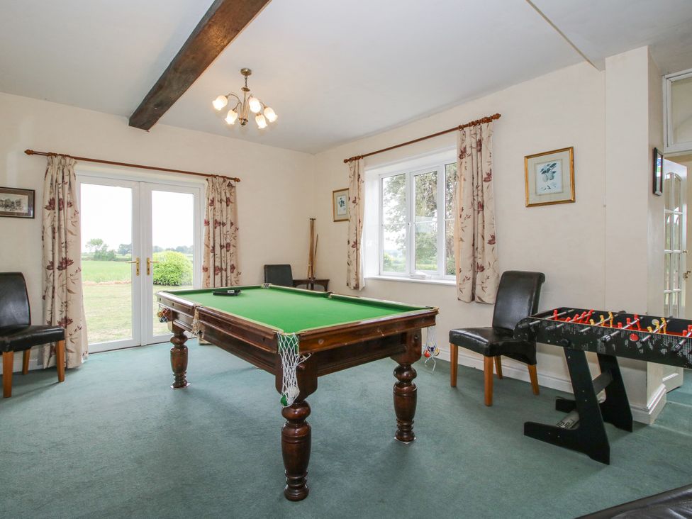 A game room with a billiard table and foosball table at The Manor House at Kenwick Lodge Cockshutt near Ellesmere