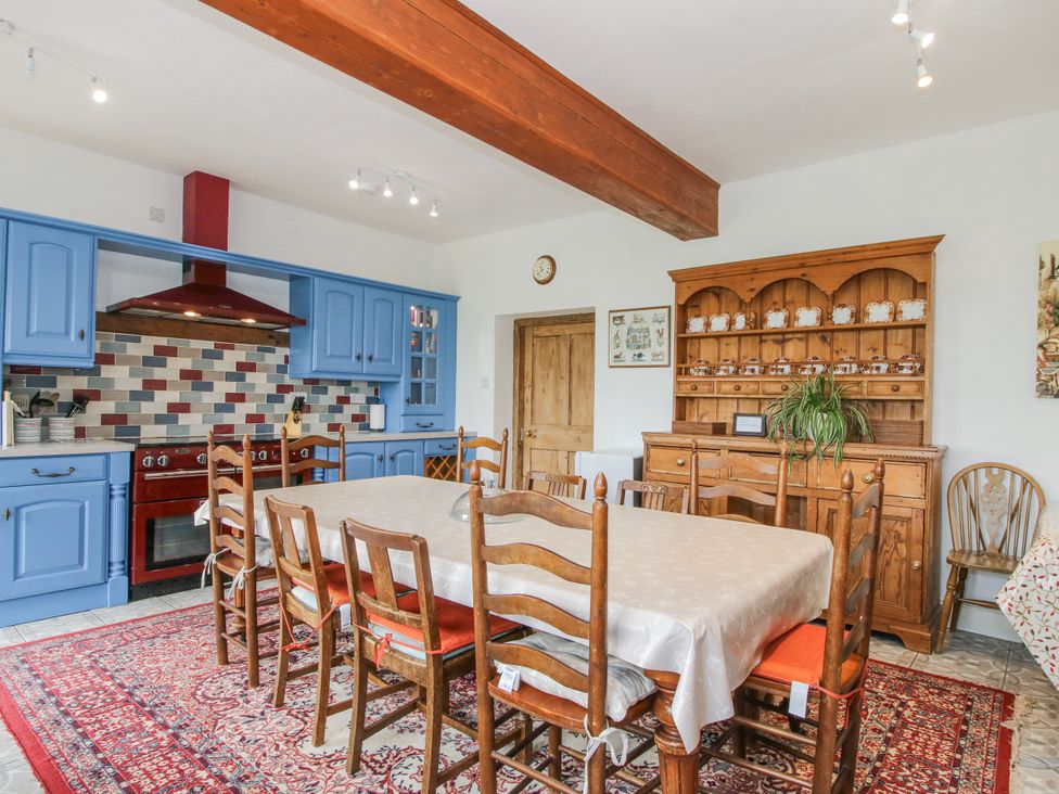 A kitchen with dining table and wooden chairs at The Manor House at Kenwick Lodge in Cockshutt near Ellesmere