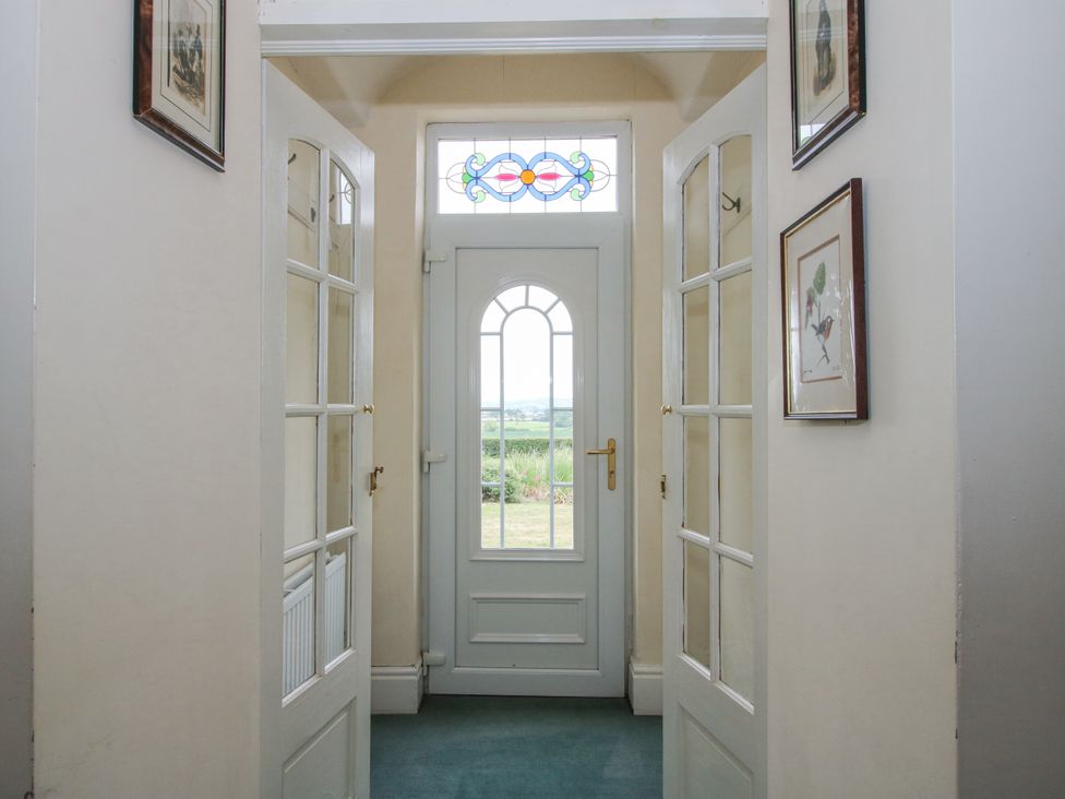 A hallway with a door and stained glass windows at The Manor House at Kenwick Lodge Cockshutt near Ellesmere