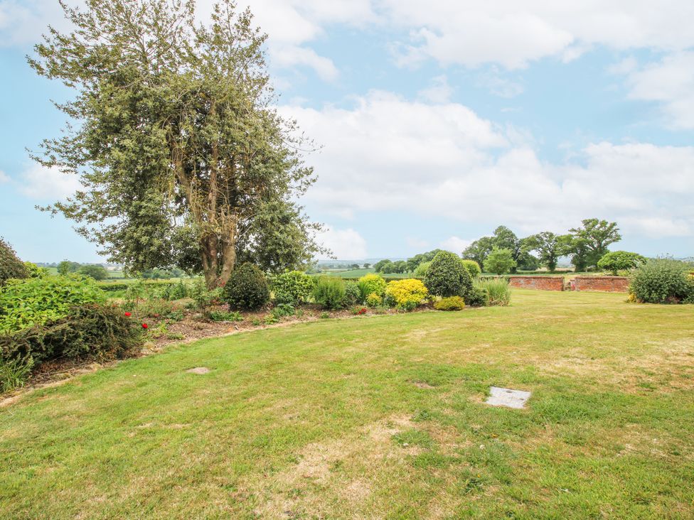 A garden with trees and shrubs at The Manor House at Kenwick Lodge Cockshutt near Ellesmere