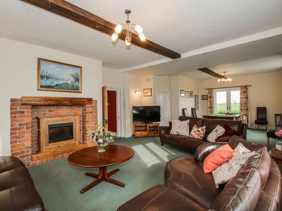 A living room with a fireplace and sofa at The Manor House at Kenwick Lodge Cockshutt near Ellesmere