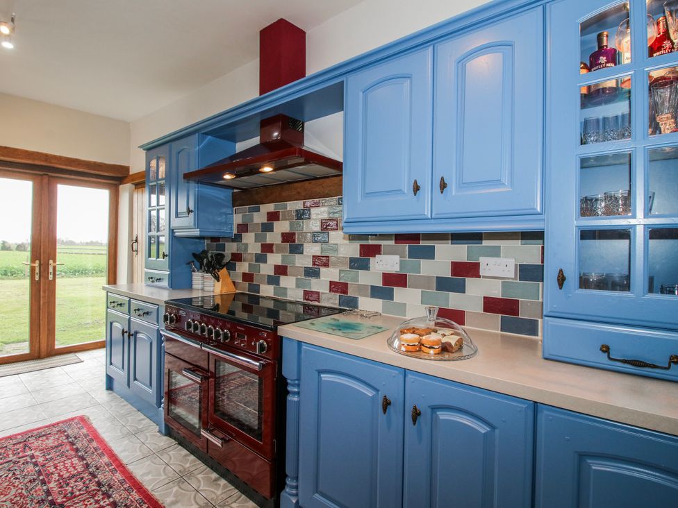 A kitchen with blue cabinets and a stove at The Manor House at Kenwick Lodge in Cockshutt near Ellesmere