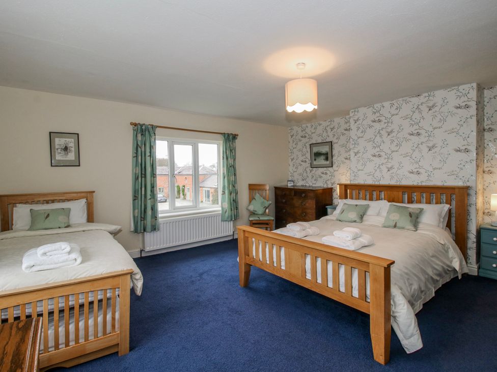 A bedroom with two beds and a dresser at The Manor House at Kenwick Lodge Cockshutt near Ellesmere