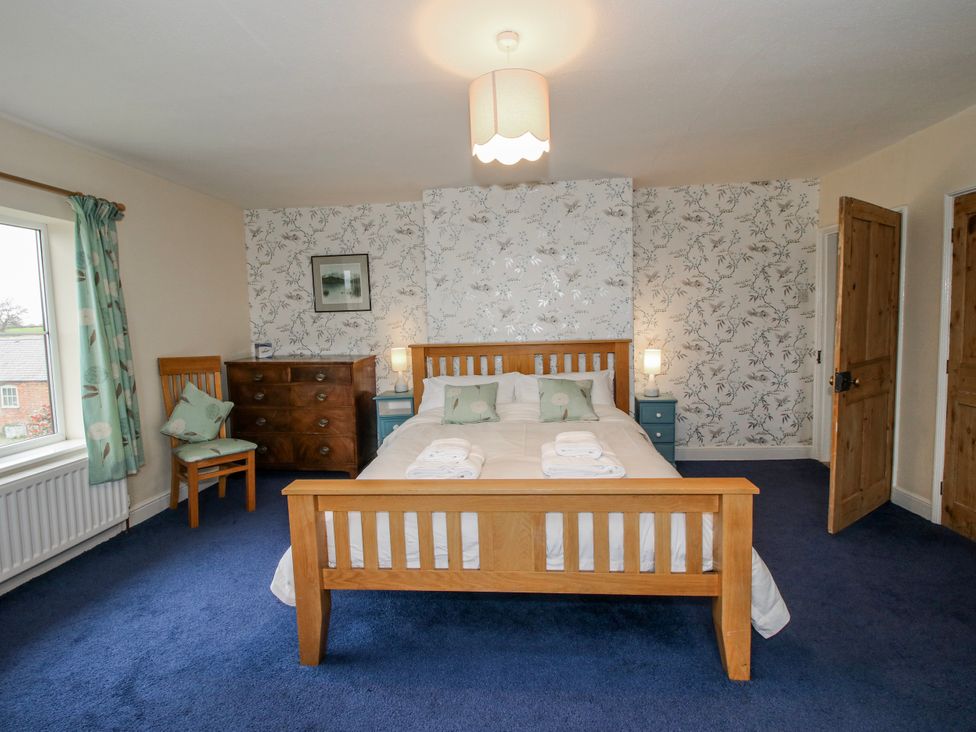 A bedroom with a bed and dresser at The Manor House at Kenwick Lodge Cockshutt near Ellesmere