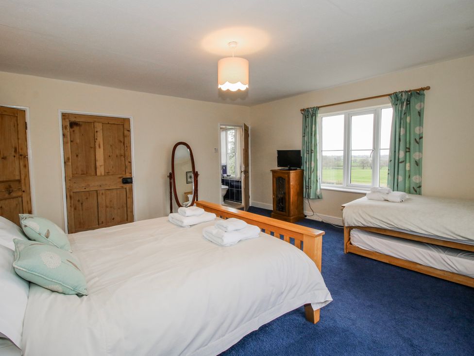 A bedroom with two beds and a television at The Manor House at Kenwick Lodge in Cockshutt near Ellesmere
