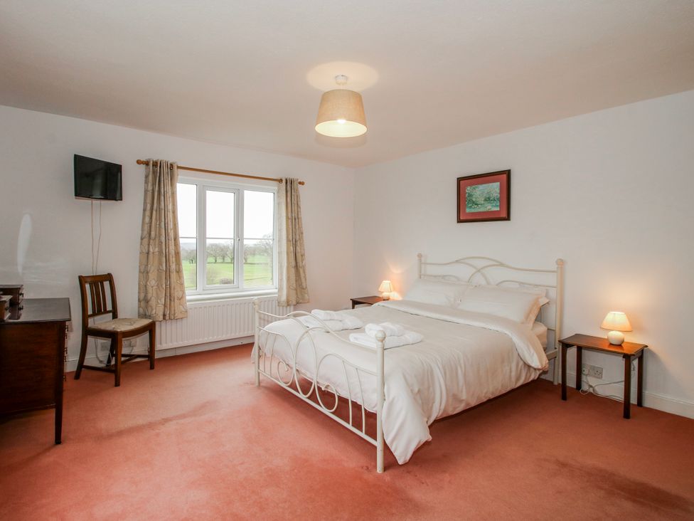 A bedroom with a bed and a table at The Manor House at Kenwick Lodge Cockshutt near Ellesmere