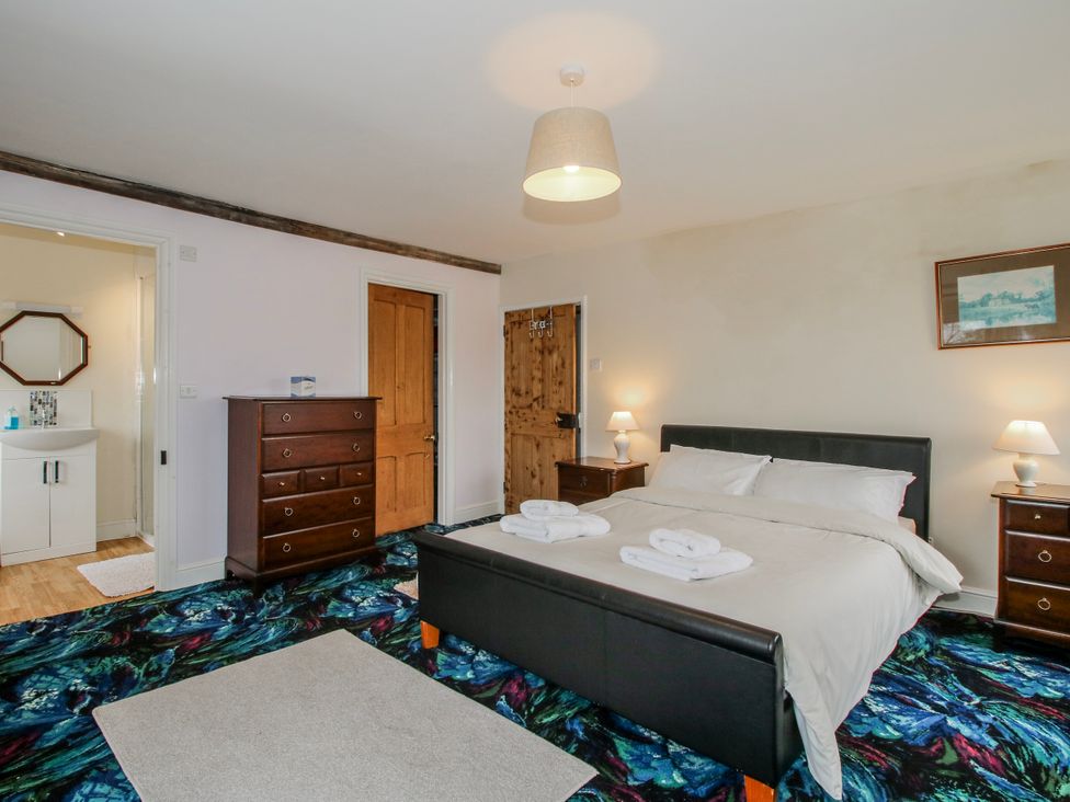 A bedroom with a bed and dresser at The Manor House at Kenwick Lodge Cockshutt near Ellesmere